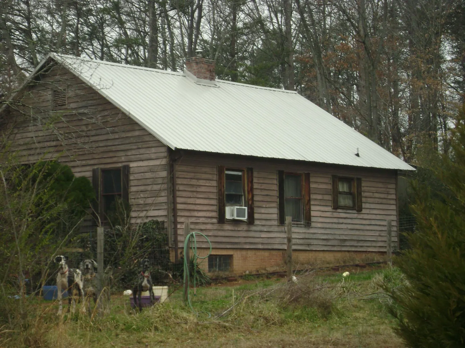 White metal roof on an old wood sided farmhouse, from a Metal Roof Installation job in Swisher